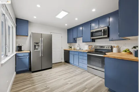a kitchen with stainless steel appliances granite countertop a refrigerator stove top oven and sink