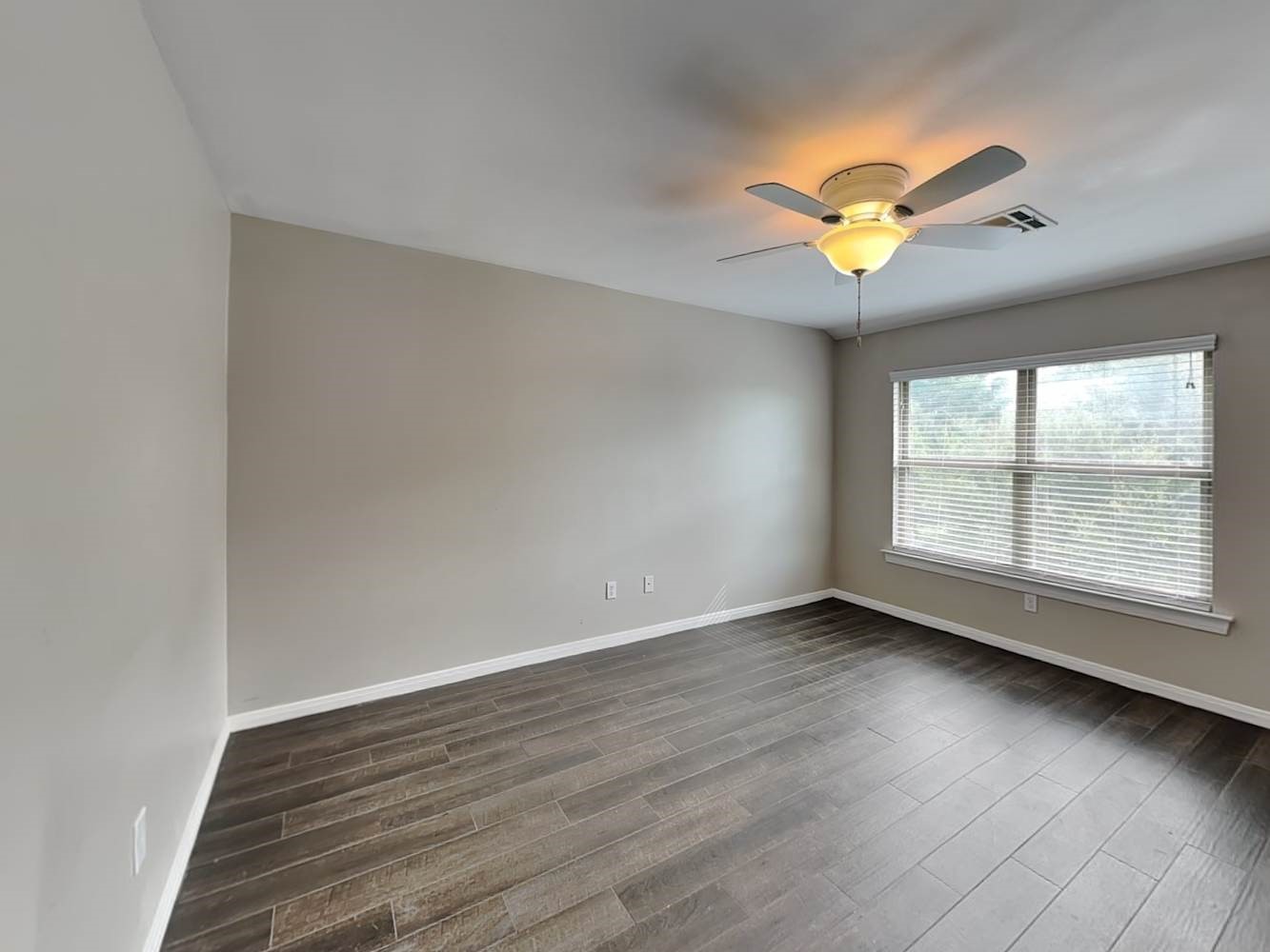 179 Holly Street, Unit 102 Georgetown, TX 78626 - Photo 11 of 17 an empty room with wooden floor and windows