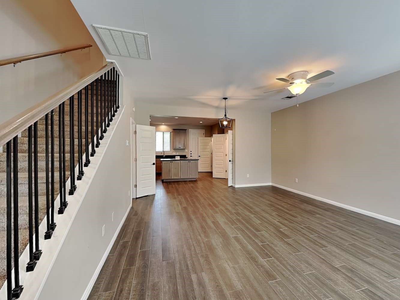 179 Holly Street, Unit 102 Georgetown, TX 78626 - Photo 2 of 17 a view of a room with wooden floor staircase and a kitchen
