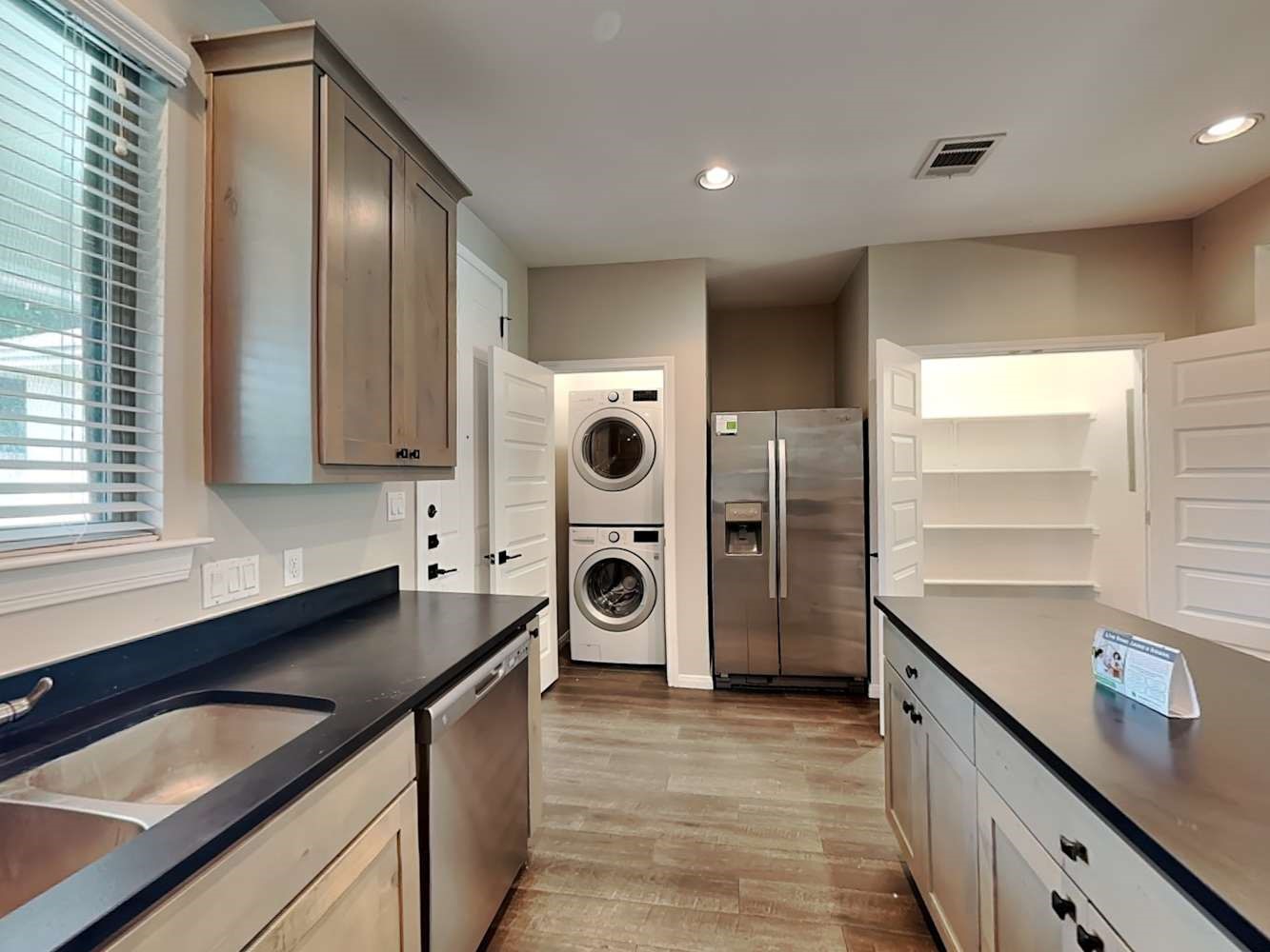 179 Holly Street, Unit 102 Georgetown, TX 78626 - Photo 9 of 17 a kitchen with a refrigerator and a sink