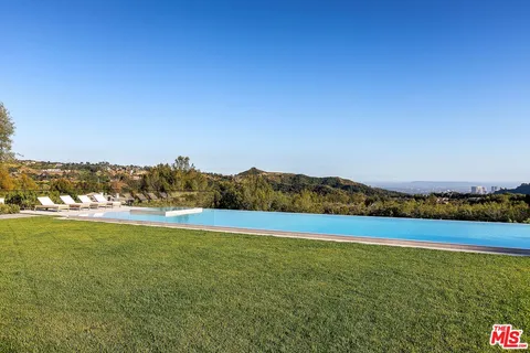 a living room with furniture and a large window with potted plants