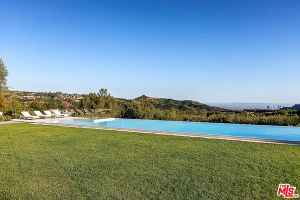 a living room with furniture and a large window with potted plants