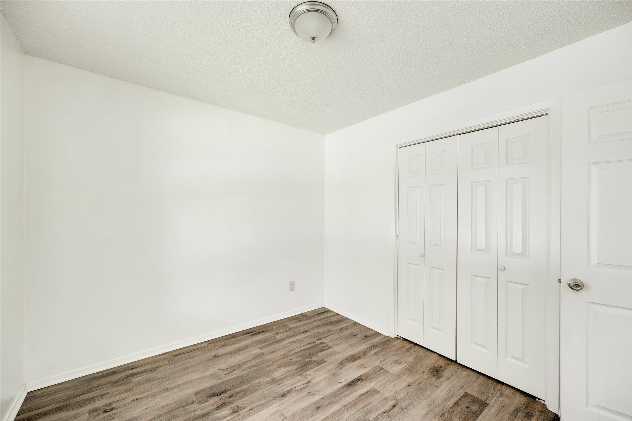 7918 West Gate Boulevard Austin, TX 78745 - Photo 7 of 31 Laminate flooring extends throughout this versatile, well-lit room, featuring a practical closet with bi-fold doors.