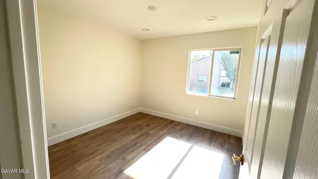 a view of an empty room and wooden floor