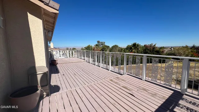 a view of balcony with wooden floor and fence