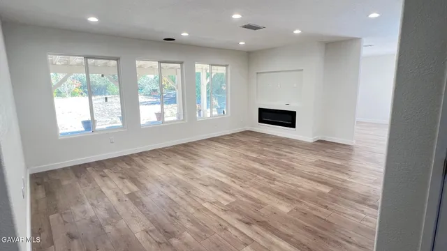 an empty room with wooden floor and a window