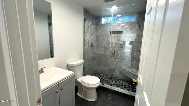 a bathroom with a shower toilet and sink