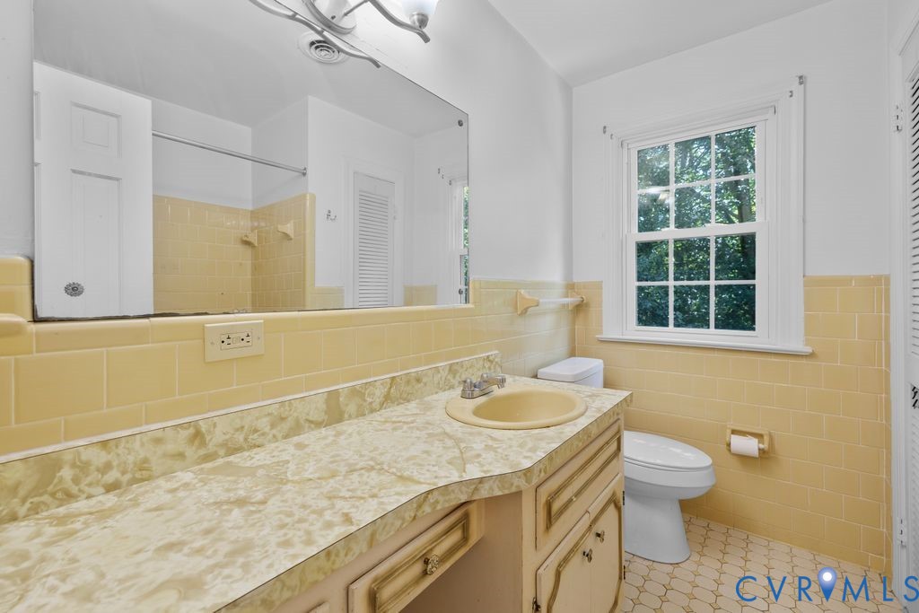 16064 Binns Road Doswell, VA 23047 - Photo 26 of 35 a bathroom with a granite countertop sink a large mirror and a window