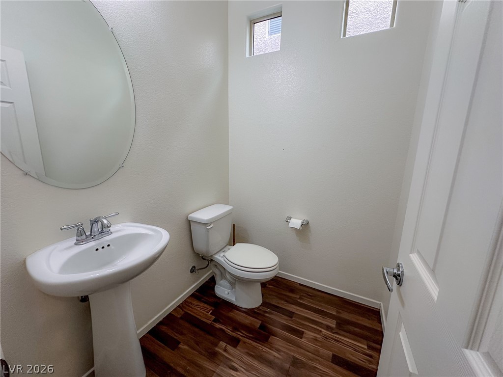 10934 Ketchikan Street Las Vegas, NV 89179 - Photo 28 of 30 Half bathroom with dark wood-style floors and toilet