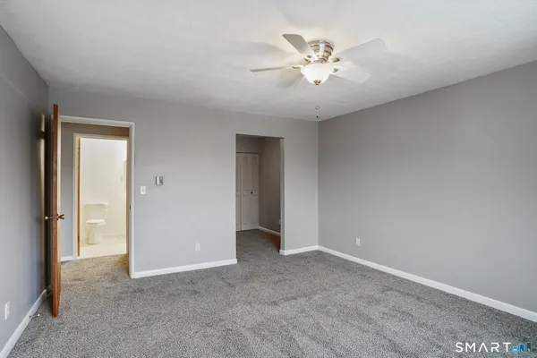 a view of an empty room with chandelier fan
