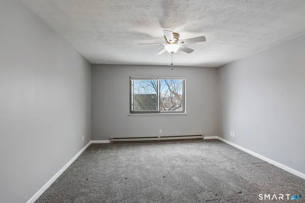 an empty room with windows and fan