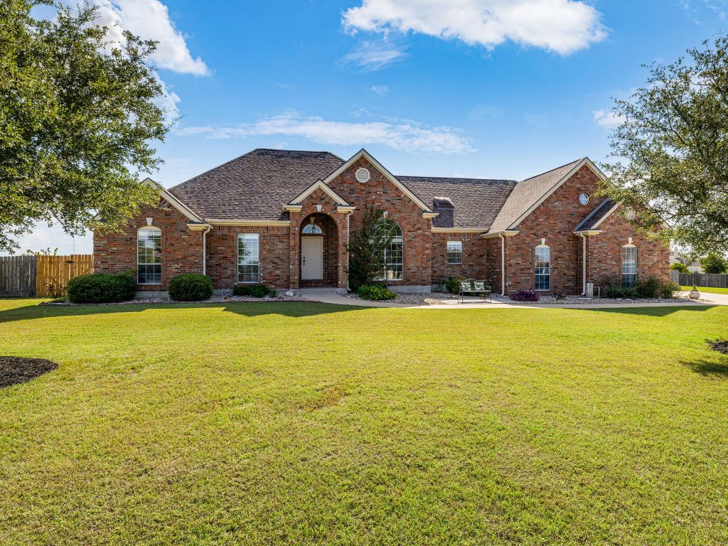 Traditional home with brick siding and roof with shingles