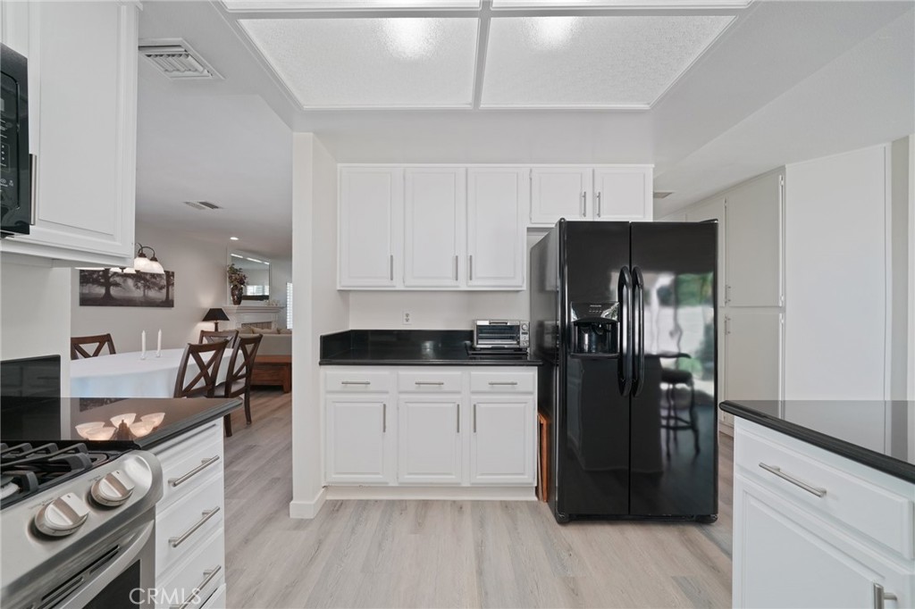 56 Dearborn Circle Redlands, CA 92374 - Photo 11 of 50 a kitchen with a refrigerator and a stove top oven
