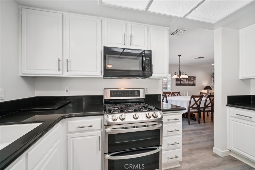 56 Dearborn Circle Redlands, CA 92374 - Photo 12 of 50 a kitchen with granite countertop a stove and a sink