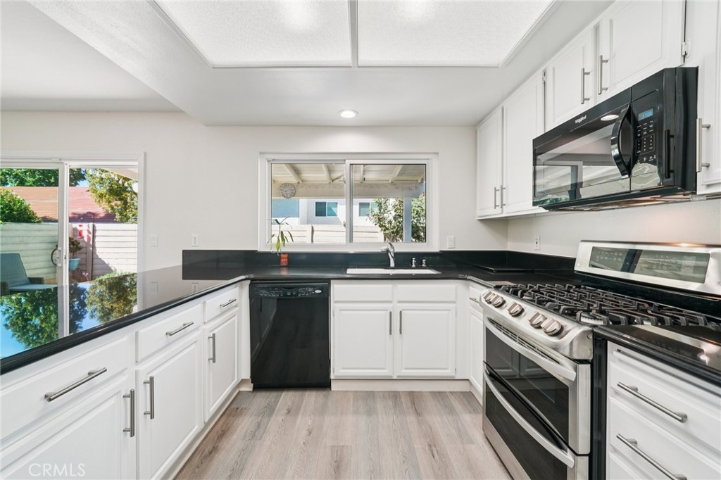 56 Dearborn Circle Redlands, CA 92374 - Photo 10 of 50 a kitchen with a sink stove and microwave