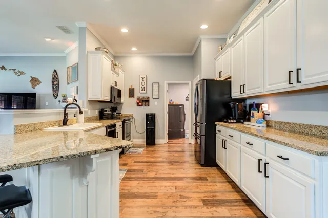 a kitchen with stainless steel appliances granite countertop a sink refrigerator and cabinets
