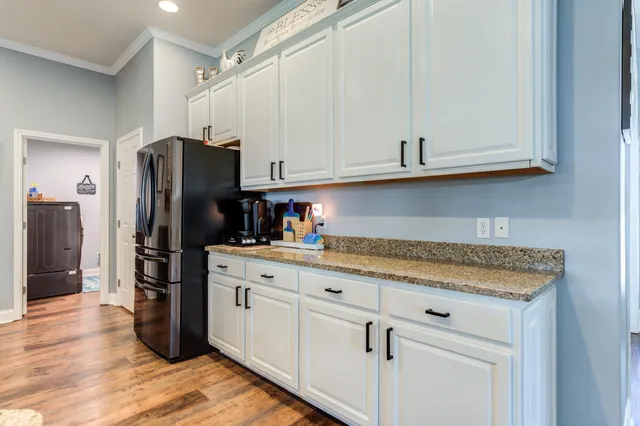a kitchen with granite countertop white cabinets and stainless steel appliances