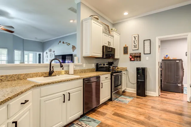a kitchen with stainless steel appliances granite countertop a refrigerator sink and white cabinets