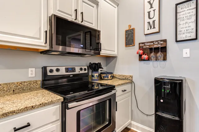 a kitchen with stainless steel appliances granite countertop a stove and a microwave
