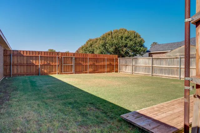 a view of a backyard with a garden and chair