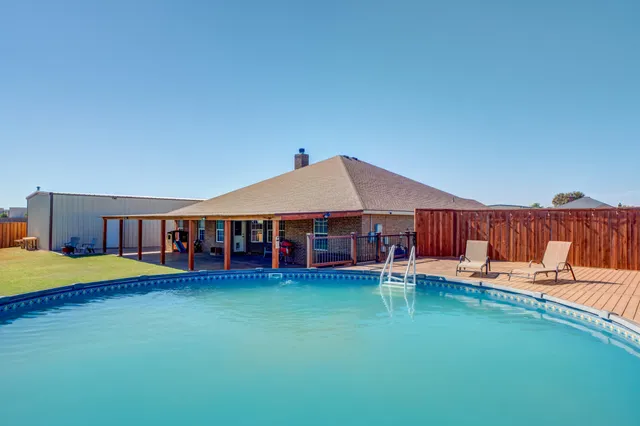 a view of a house with pool and a yard