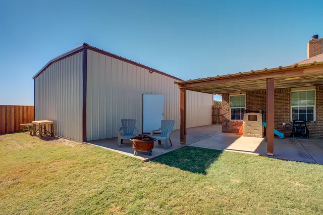 a view of a house with backyard and sitting area