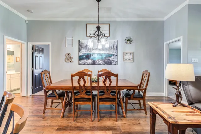 a view of a dining room and livingroom with furniture wooden floor a chandelier