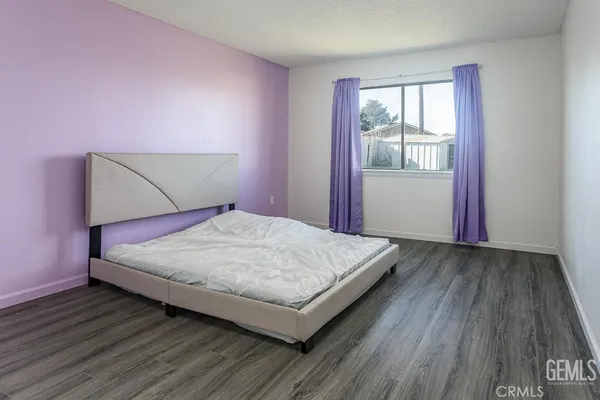 a bed sitting in a bedroom next to a window