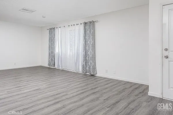 a view of a room with wooden floor and white walls