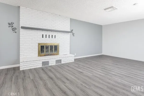 a view of empty room with wooden floor and fireplace