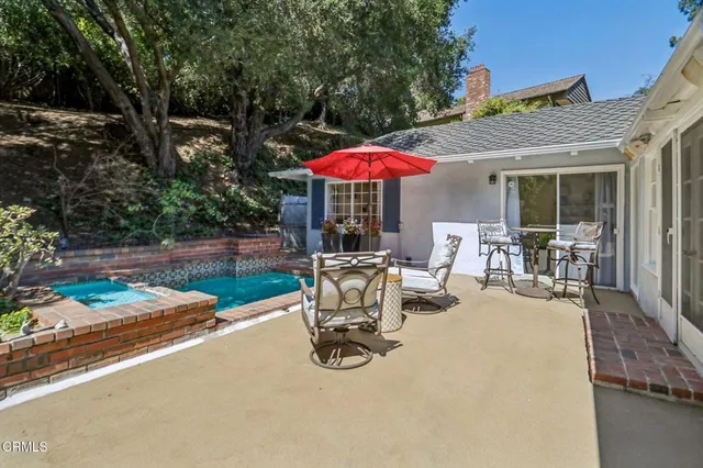 a view of a backyard with table and chairs under an umbrella