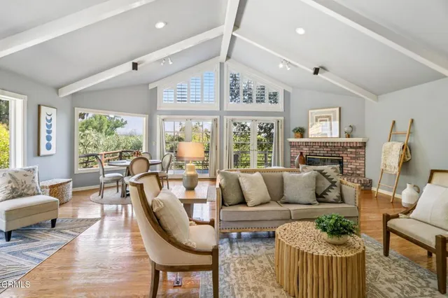 a living room with fireplace furniture and a large window