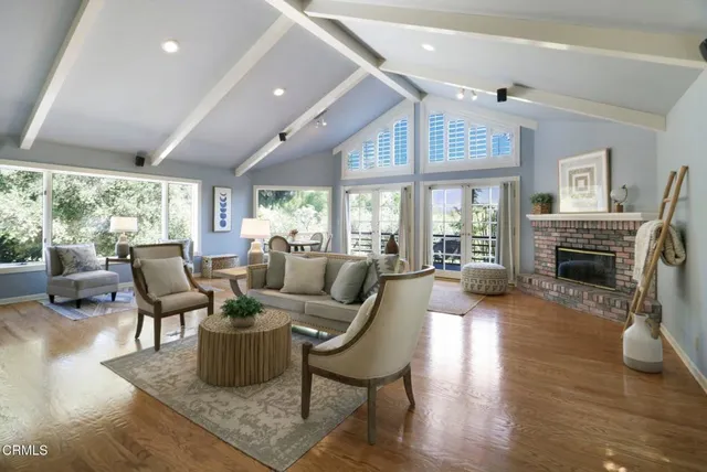 a living room with fireplace furniture and a large window