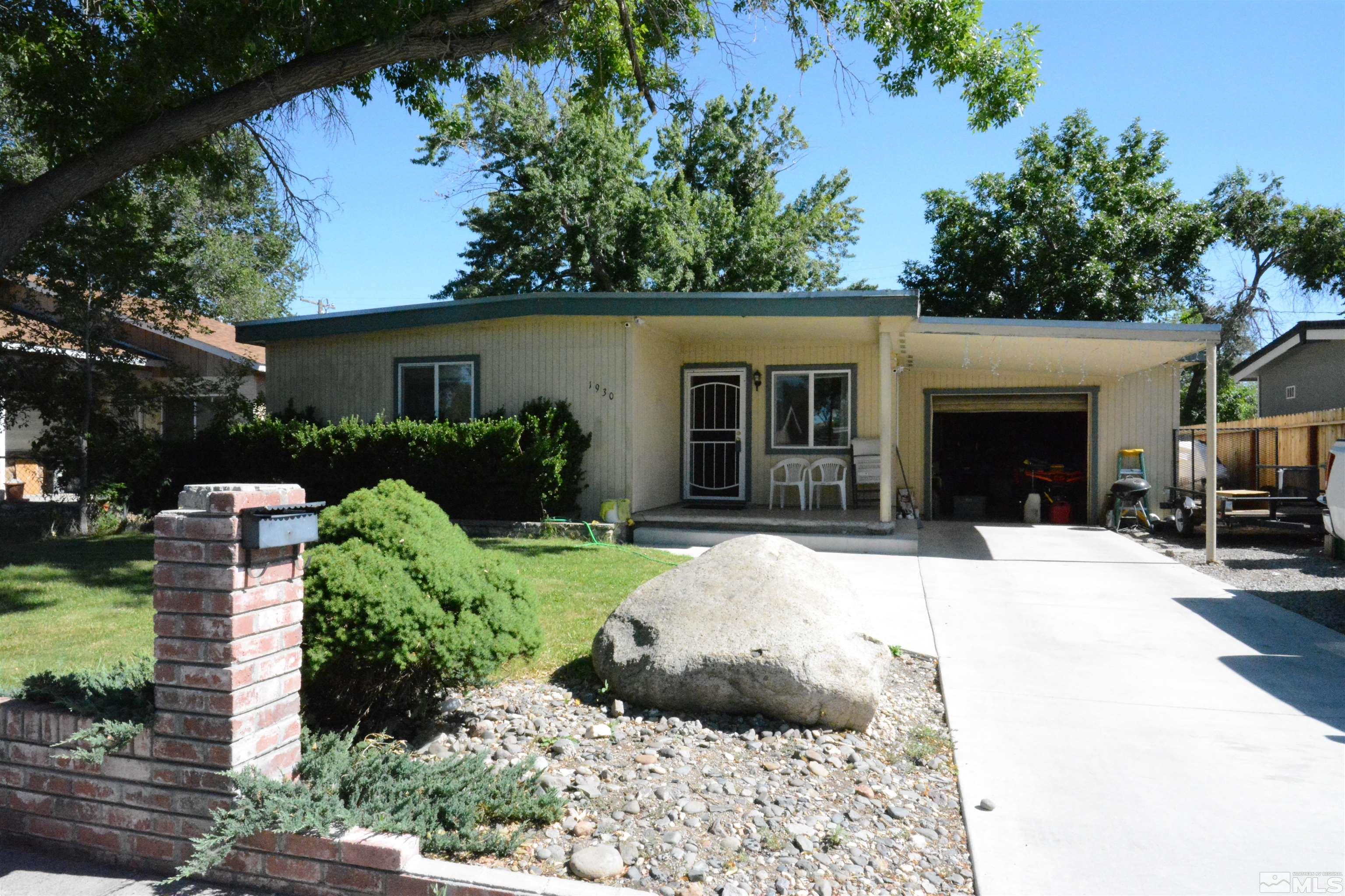 front view of a house with a yard and potted plants
