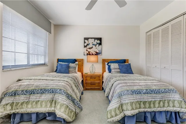 a bedroom with two beds and window