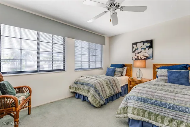 a bedroom with two beds and painting on the wall