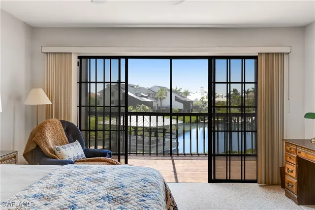 a bedroom with a bed and a lamp next to a window