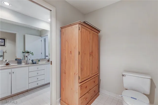 a bathroom with a granite countertop toilet sink and mirror