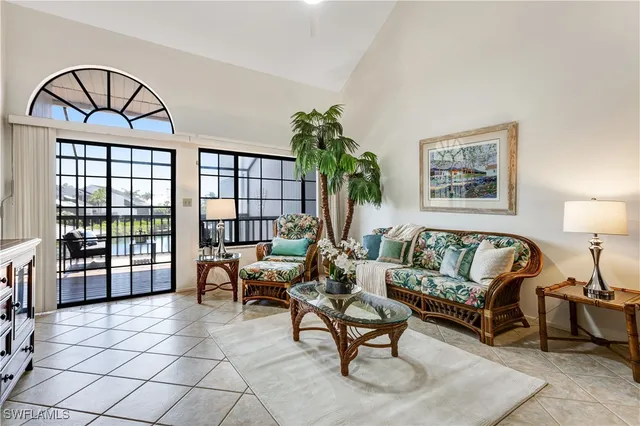 a living room with furniture a rug a table and a large window