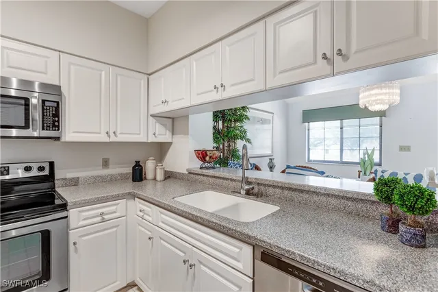 a kitchen with appliances a sink and cabinets
