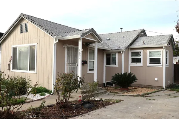 a front view of a house with a yard and potted plants