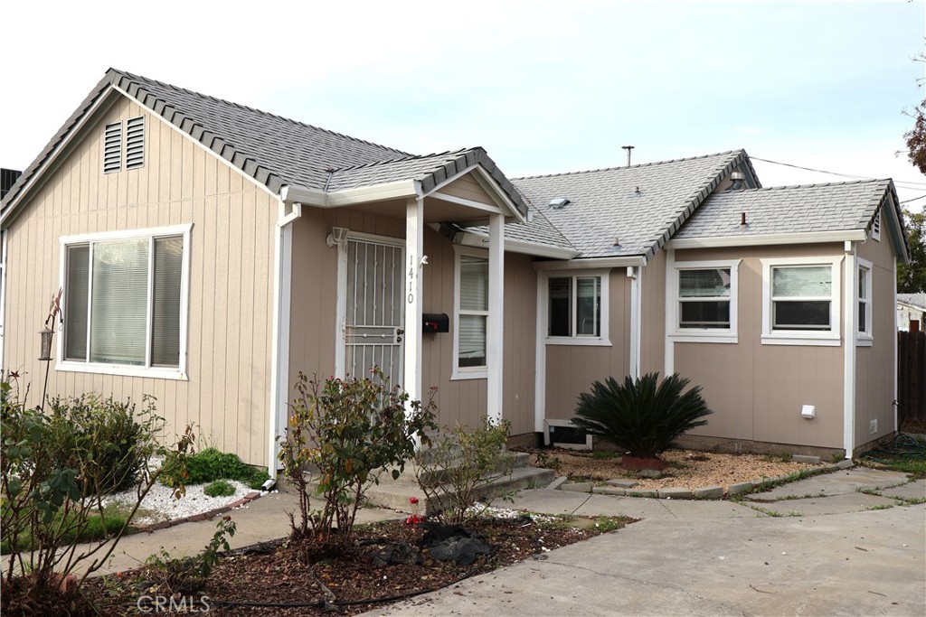 1410 4th Corning, CA 96021 - Photo 1 of 26 a front view of a house with a yard and potted plants