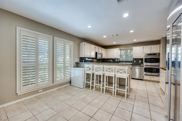 a kitchen with stainless steel appliances kitchen island granite countertop a refrigerator and cabinets