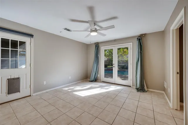 a view of an empty room with window chandelier fan and fire place