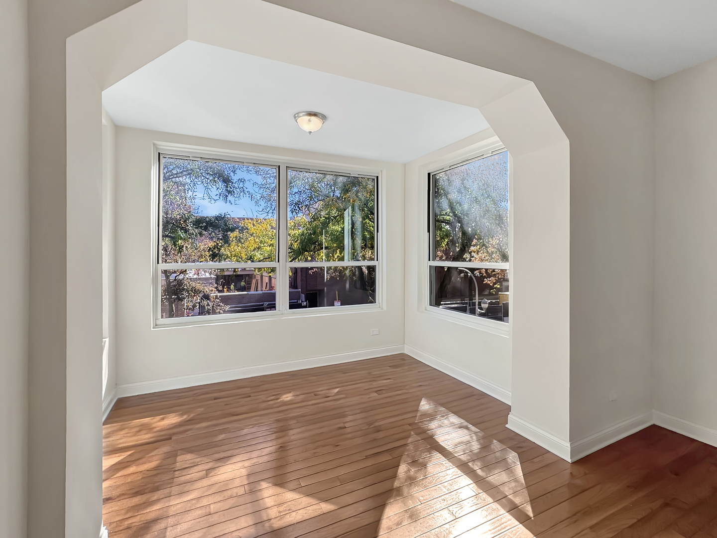 710 West Grace Street, Unit 2 Chicago, IL 60613 - Photo 2 of 12 a view of an empty room with wooden floor and a window