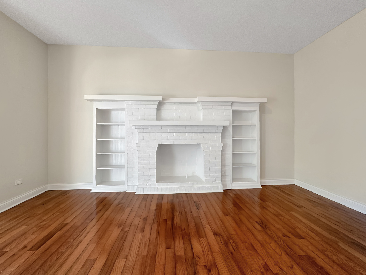 710 West Grace Street, Unit 2 Chicago, IL 60613 - Photo 4 of 12 a view of empty room with wooden floor and fireplace