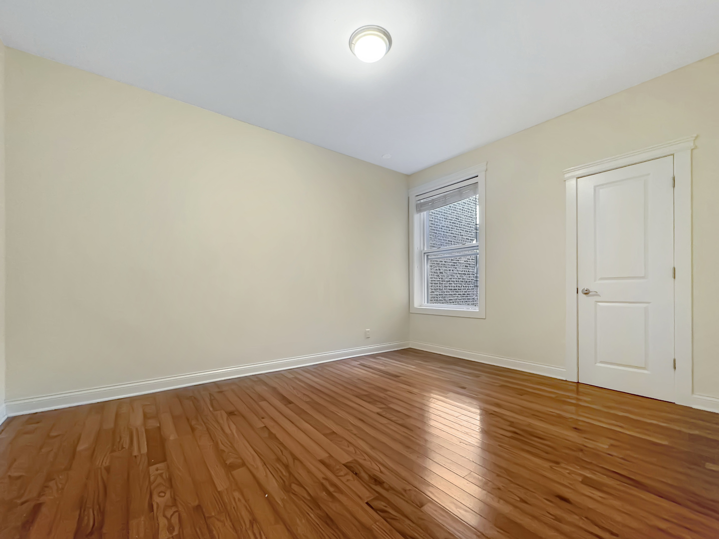 710 West Grace Street, Unit 2 Chicago, IL 60613 - Photo 9 of 12 a view of an empty room with wooden floor and a window