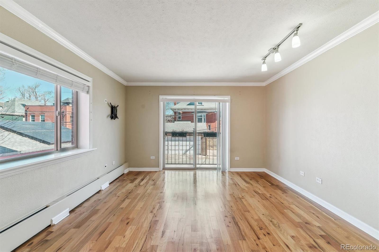 1330 Elizabeth Street, Unit 8 Denver, CO 80206 - Photo 4 of 15 a view of empty room with wooden floor and fan