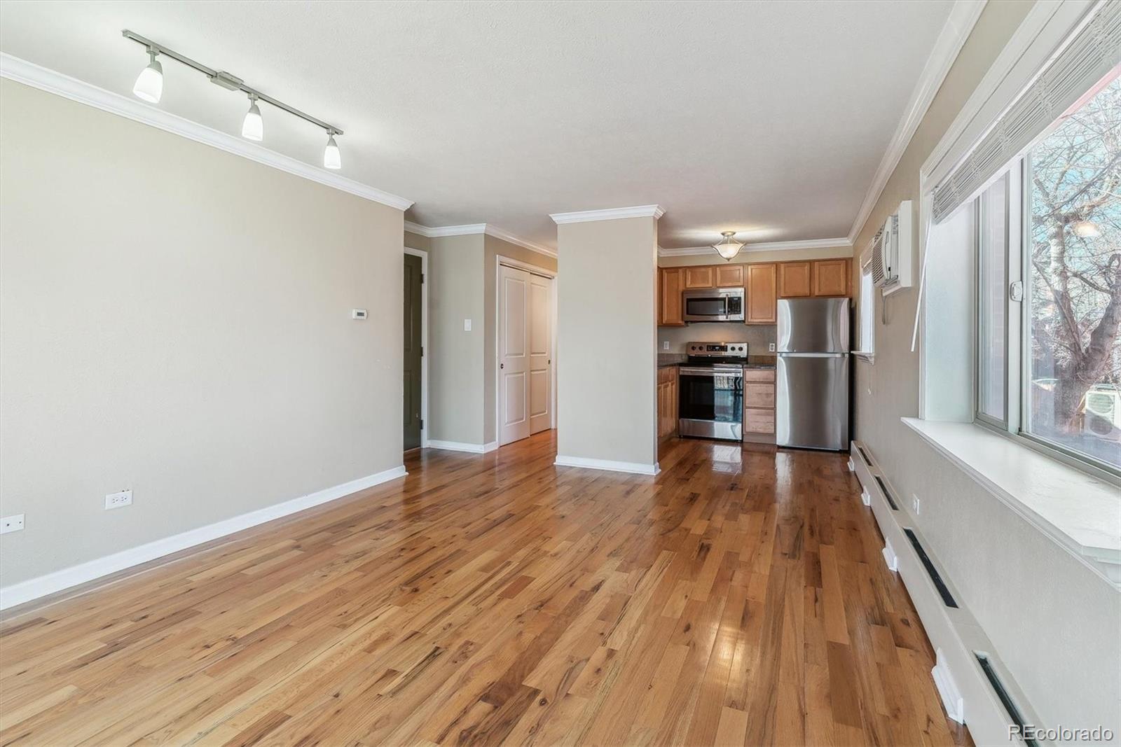 1330 Elizabeth Street, Unit 8 Denver, CO 80206 - Photo 6 of 15 a view of a kitchen with wooden floor and a ceiling fan