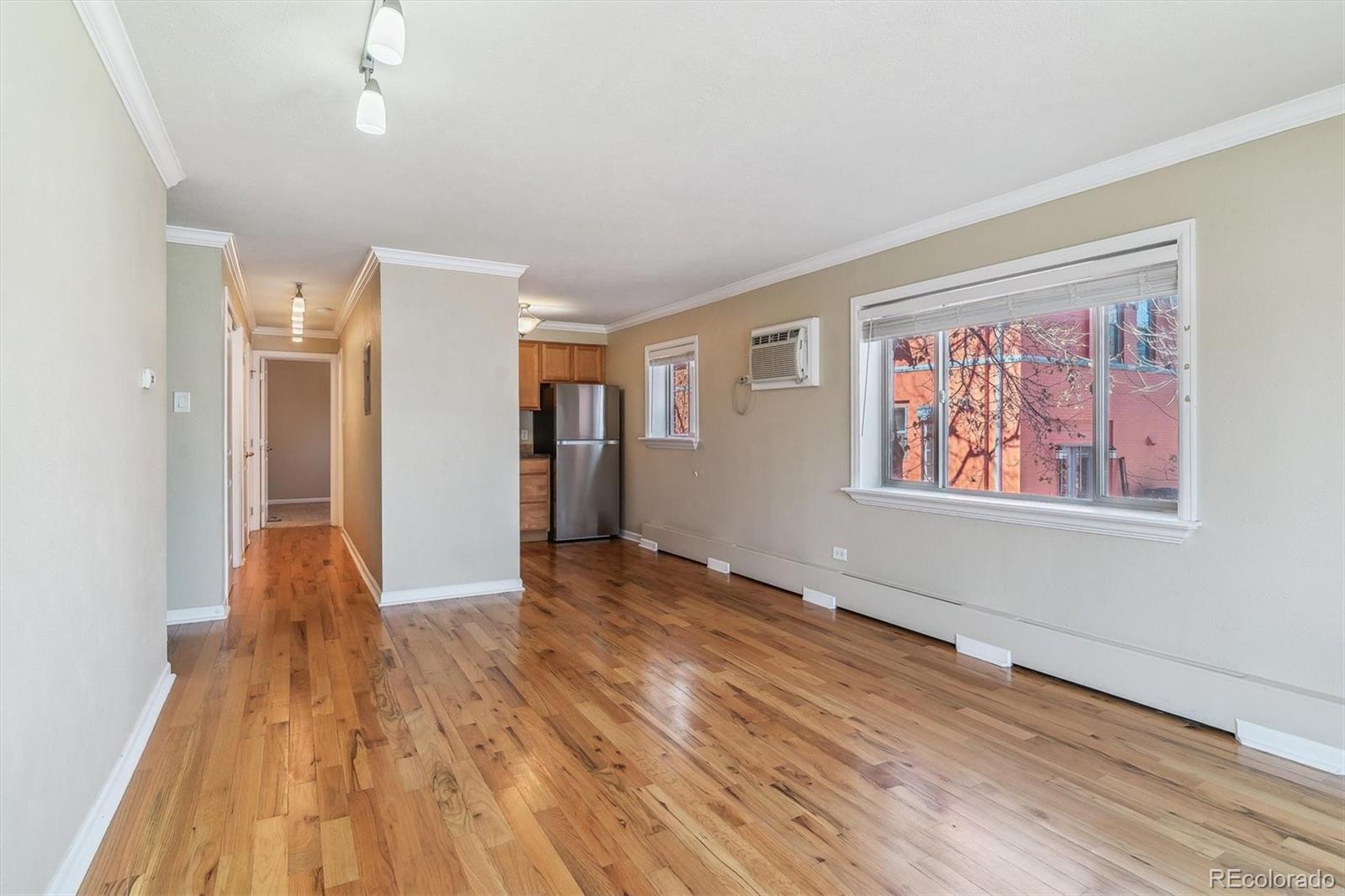 1330 Elizabeth Street, Unit 8 Denver, CO 80206 - Photo 7 of 15 a view of an empty room with wooden floor and a window